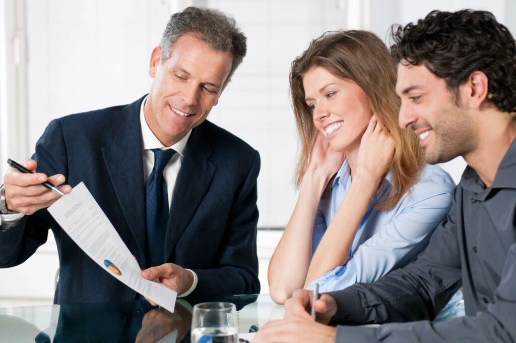 Businessman discussing contract with couple.