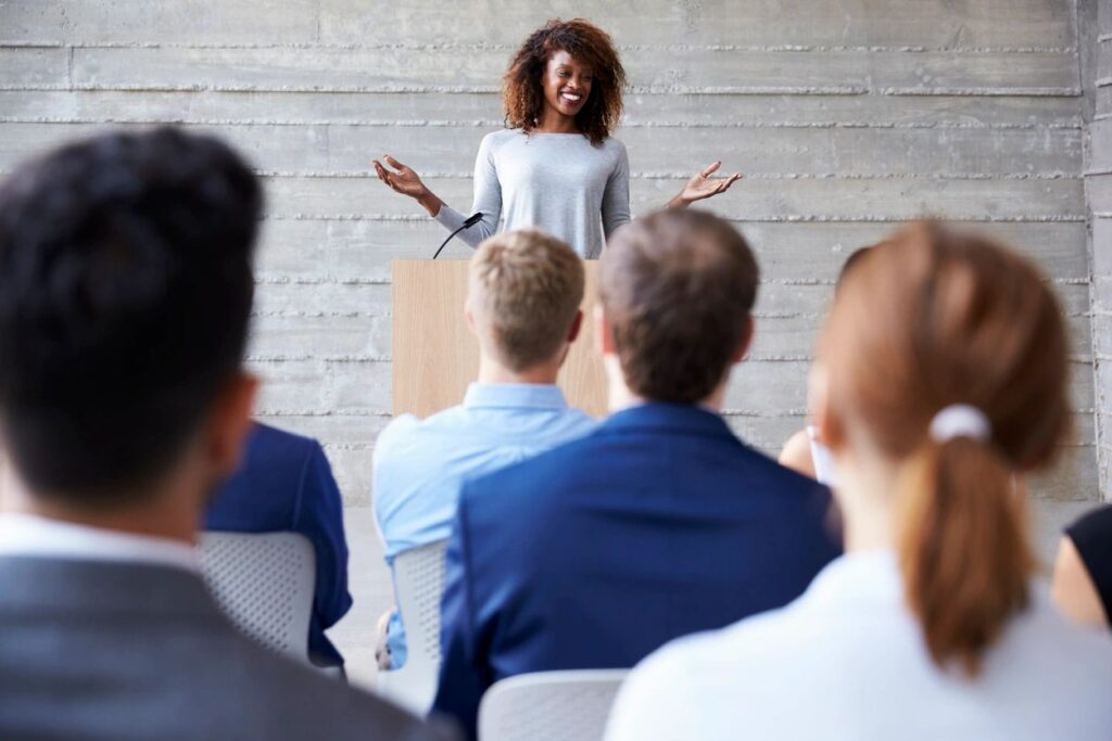 Woman giving a presentation to audience.