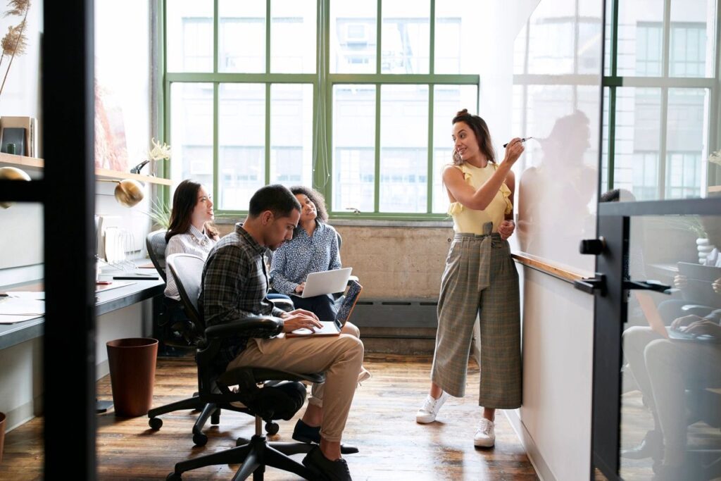 Woman presenting to colleagues in office.