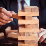 Person playing wooden block stacking game.