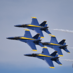 Four blue and yellow jets in formation.